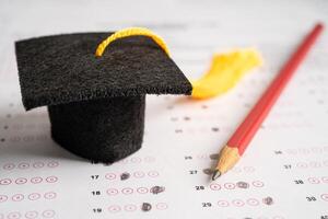 laurea cappello e matita sul foglio delle risposte sfondo, studio di istruzione test di apprendimento insegnano il concetto. foto