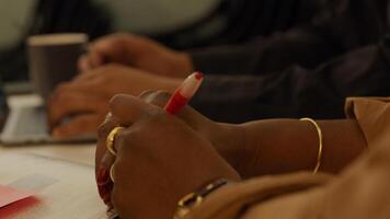 stretta di mano sul tavolo della donna matura nera, tenendo la penna foto