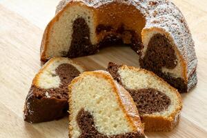 tradizionale fatti in casa marmo torta. affettato marmo bundt torta su di legno tavolo foto