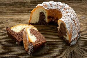 tradizionale fatti in casa marmo torta. affettato marmo bundt torta su di legno tavolo foto