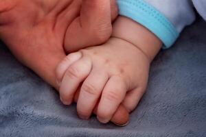 bambino mano Tenere La madre di dito foto