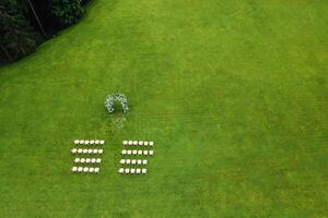 superiore Visualizza di il nozze sede nel un' verde campo. nozze cerimonia con decorato arredamento su un' verde prato.matrimonio tradizione foto