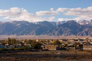 piccolo kirghiso cittadina balykchy paesaggio urbano nel davanti di massiccio montagna cresta foto