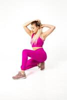 donna nel vivace rosa gli sport attrezzatura in ginocchio con mani su capelli foto