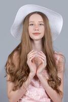ritratto di un' romantico ragazza con lungo biondo capelli nel un' a tesa larga cappello. foto