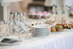 buffet tavolo con piatti e spuntini.a pila di bianca piatti su il tavolo di il buffet tavolo foto