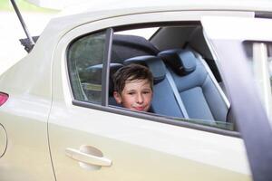 allegro gioioso bambino nel il auto mentre in viaggio. foto