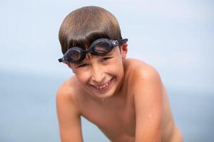 contento bambino dopo nuoto indossare nuoto occhiali. foto
