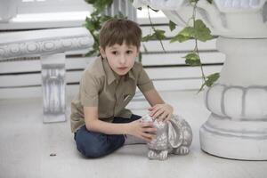 ceramica argilla lepre bambino.piccolo ragazzo con un artificiale animale foto