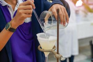 sperimentare per separato misto sostanze di scrosciante sostanze in un' separatore imbuto attraverso filtro carta. solido particelle siamo posto su il filtro carta. il liquido volontà flusso in il coppa sotto. foto