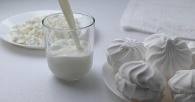 scrosciante latte nel bicchiere a partire dal un' bottiglia su un' leggero sfondo. prima colazione cibo e dolce. salutare e latteria Prodotto concetto. vicino su foto