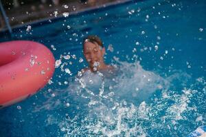 un' bambino nel un' piscina con un gonfiabile squillare foto