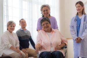 asiatico giovane infermiera supporto coppia anziano più vecchio donna nel un' sedia a rotelle. anziano maturo e un' gruppo di anziano amici vivente nel il Ospedale. socializzazione di pensionato le persone. foto