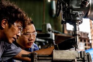 asiatico lavoratore nel produzione pianta perforazione a macchina. professionale lavoratore vicino perforazione macchina su fabbrica. finitura metallo Lavorando interno acciaio superficie su tornio macinino macchina con volante scintille. foto