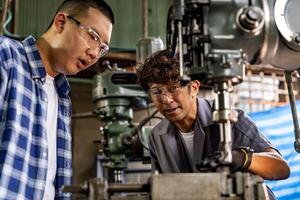 asiatico lavoratore nel produzione pianta perforazione a macchina. professionale lavoratore vicino perforazione macchina su fabbrica. finitura metallo Lavorando interno acciaio superficie su tornio macinino macchina con volante scintille. foto