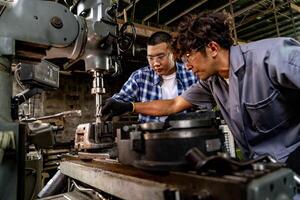 asiatico lavoratore nel produzione pianta perforazione a macchina. professionale lavoratore vicino perforazione macchina su fabbrica. finitura metallo Lavorando interno acciaio superficie su tornio macinino macchina con volante scintille. foto