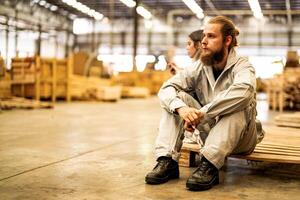 uomo lavoratori ingegneria seduta con fiducia con Lavorando suite vestito e mano guanto nel davanti macchina. concetto di inteligente industria lavoratore operativo. legna fabbrica produrre legna palato. foto