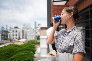 africano attività commerciale inteligente donna sta a all'aperto terrazza costruzione. persone con su mano nel bene sensazione con città spazio costruzione. rilassante di persone attività commerciale mattina. foto