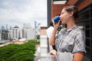 africano attività commerciale inteligente donna sta a all'aperto terrazza costruzione. persone con su mano nel bene sensazione con città spazio costruzione. rilassante di persone attività commerciale mattina. foto