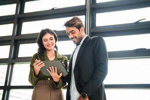 attività commerciale persone avendo divertimento e chat a posto di lavoro ufficio. maschio e femmina collega godere incontro a co Lavorando spazio. colleghi discutere di il progetto nel il ufficio. foto