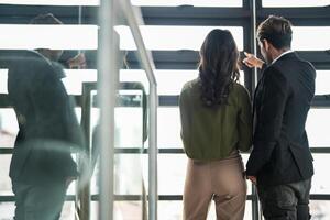 attività commerciale persone avendo divertimento e chat a posto di lavoro ufficio. maschio e femmina collega godere incontro a co Lavorando spazio. colleghi discutere di il progetto nel il ufficio. foto