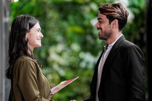 uomo d'affari e casuale donna d'affari tremante mani all'aperto. Due giovane multiculturale collaboratori affare per successo. sfondo di verde parete natura alberi. foto