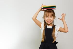 poco divertente ragazza nel camicia con libri. isolato su bianca sfondo. bambino ragazza nel scuola. il bambino ragazza con libri di testo. ragazza studiare. foto