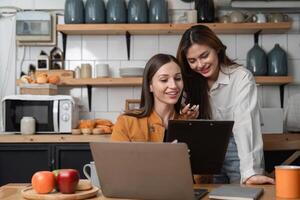 Due attività commerciale donne opera insieme a casa ufficio Condividere il tuo opinioni di Lavorando in linea. foto