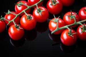 fresco ciliegia pomodori su un' nero sfondo. mazzo di fresco ciliegia pomodoro su un' nero sfondo foto