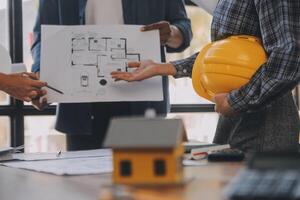 un' squadra di costruzione ingegneri parla per manager e costruzione lavoratori a il costruzione luogo. qualità ispezione, opera Piano, casa e industriale edificio design progetto foto