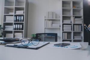 gli analisti finanziari analizzano i rapporti finanziari aziendali su un progetto di investimento di pianificazione di un tablet digitale durante una discussione in una riunione aziendale che mostra i risultati del loro lavoro di squadra di successo. foto