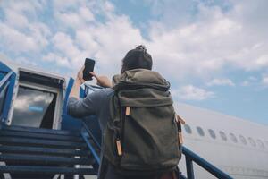 contento attraente asiatico donna viaggiatore con zaino a il moderno aeroporto terminale, copia spazio, turista viaggio viaggio concetto foto