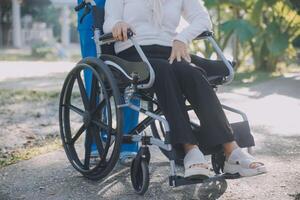 infermiera con anziano uomo nel sedia a rotelle a parco foto