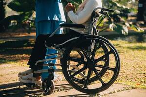 assistenza infermieristica personale parlando per un anziano persona seduta nel un' sedia a rotelle. foto