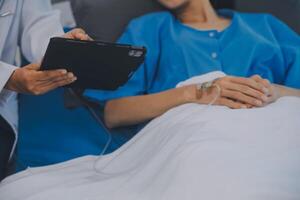 asiatico medico rendere routine Salute dai un'occhiata con paziente nel ospedale reparto foto