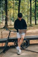 bello contento giovane uomo con bicicletta su un' città strada, attivo stile di vita, persone concetto foto