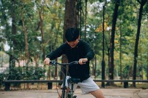 bello contento giovane uomo con bicicletta su un' città strada, attivo stile di vita, persone concetto foto