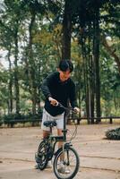 bello contento giovane uomo con bicicletta su un' città strada, attivo stile di vita, persone concetto foto