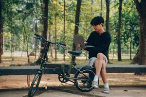 bello contento giovane uomo con bicicletta su un' città strada, attivo stile di vita, persone concetto foto