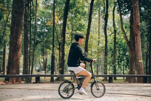 bello contento giovane uomo con bicicletta su un' città strada, attivo stile di vita, persone concetto foto