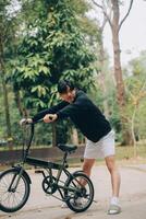 bello contento giovane uomo con bicicletta su un' città strada, attivo stile di vita, persone concetto foto