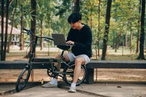 bello contento giovane uomo con bicicletta su un' città strada, attivo stile di vita, persone concetto foto