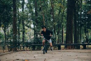 bello contento giovane uomo con bicicletta su un' città strada, attivo stile di vita, persone concetto foto