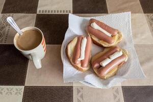 caldo panini con formaggio, salsicce e Maionese con tazza di caffè con latte foto