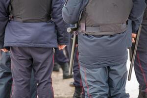 russo polizia ufficiale con nero gomma da cancellare tonfa bastone sospeso su il suo cintura foto