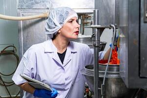 caucasion donna Lavorando nel un' cibo fabbrica indossare protettivo Abiti e guanti. foto