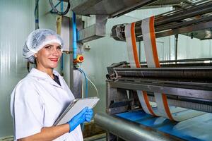 caucasion donna Lavorando nel un' cibo fabbrica indossare protettivo Abiti e guanti. foto