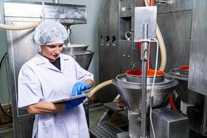 caucasion donna Lavorando nel un' cibo fabbrica indossare protettivo Abiti e guanti. foto