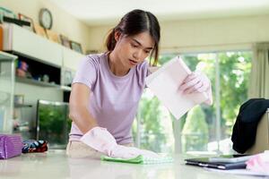 asiatico donna pulito su il vivente camera, appartamento o casa la zona. foto