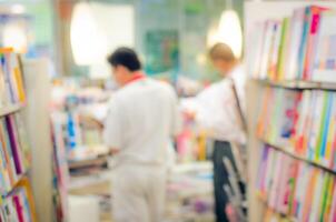 focalizzata sfocatura Immagine di un' libreria con i clienti lettura e guardare per libri. libreria sfondo. foto